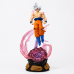 Dragon Ball Ultra Instinct Goku LED PVC figure with silver hair, glowing energy aura, illuminated display base, and detailed translucent pink effects on a white background.