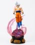 Dragon Ball Ultra Instinct Goku LED PVC figure with silver hair, glowing energy aura, illuminated display base, and detailed translucent pink effects on a white background.