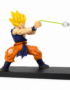 Dragon Ball Super Saiyan Goku PVC figure in a Kamehameha charging pose with battle-damaged clothing, green energy effect support, and black display base on a white background.