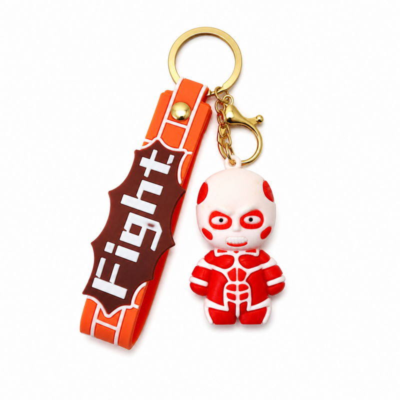 Attack on Titan Colossal Titan chibi PVC keychain with a Scout Regiment silicone wrist strap, gold-tone keyring, lobster clasp, and detailed red-and-white Titan design on a white background.